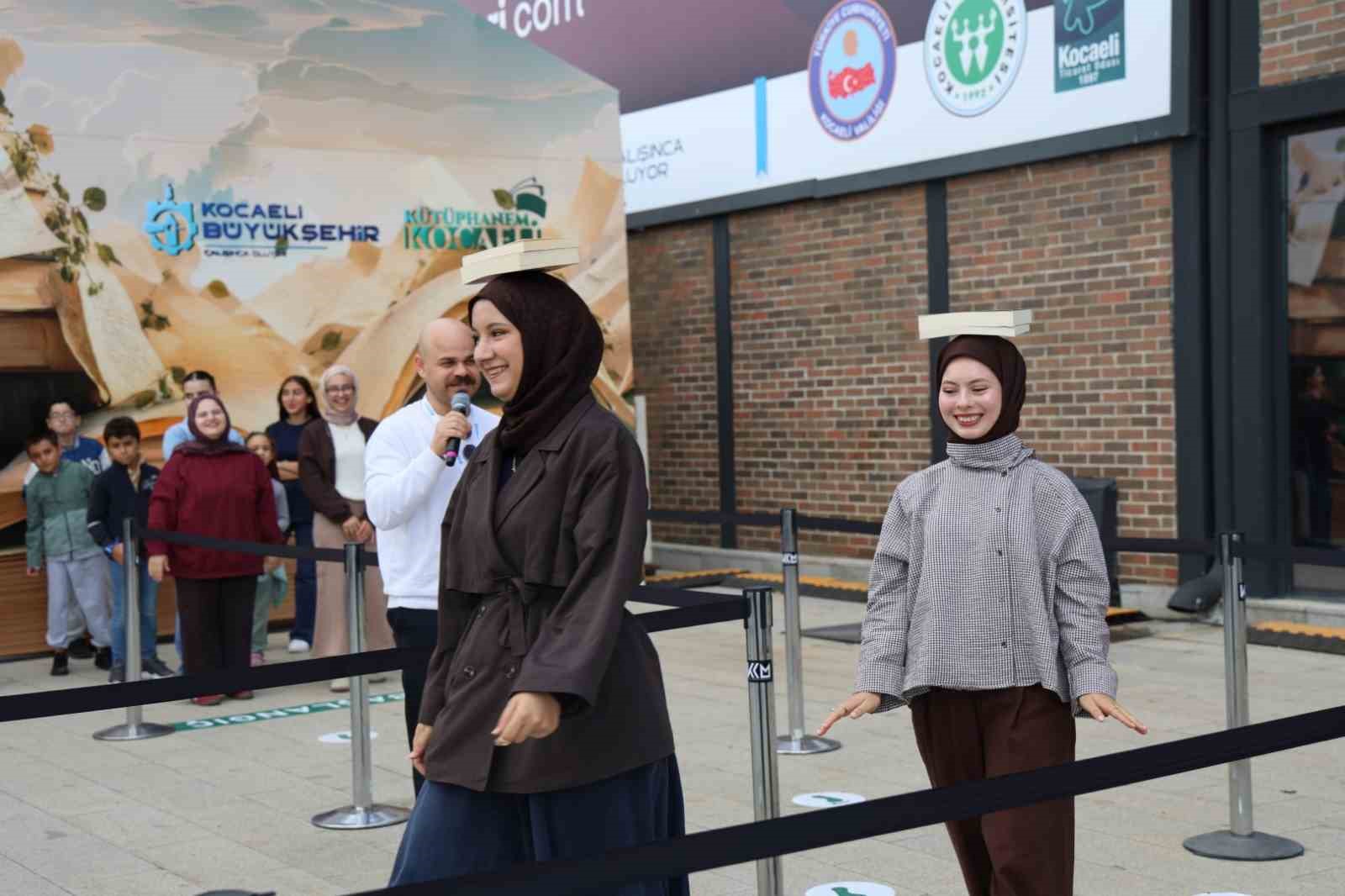 KOCAELİ KİTAP FUARI’NDA ZİYARETÇİLER, “BAŞIMIN ÜSTÜNDE YERİN VAR” OYUNUNDA KİTAPLARI BAŞLARININ ÜZERİNDE DÜŞÜRMEDEN TAŞIMAK İÇİN YARIŞTI. DENGE VE DİKKAT GEREKTİREN OYUN, FUAR ALANINDA RENKLİ VE EĞLENCELİ GÖRÜNTÜLERE SAHNE OLDU.