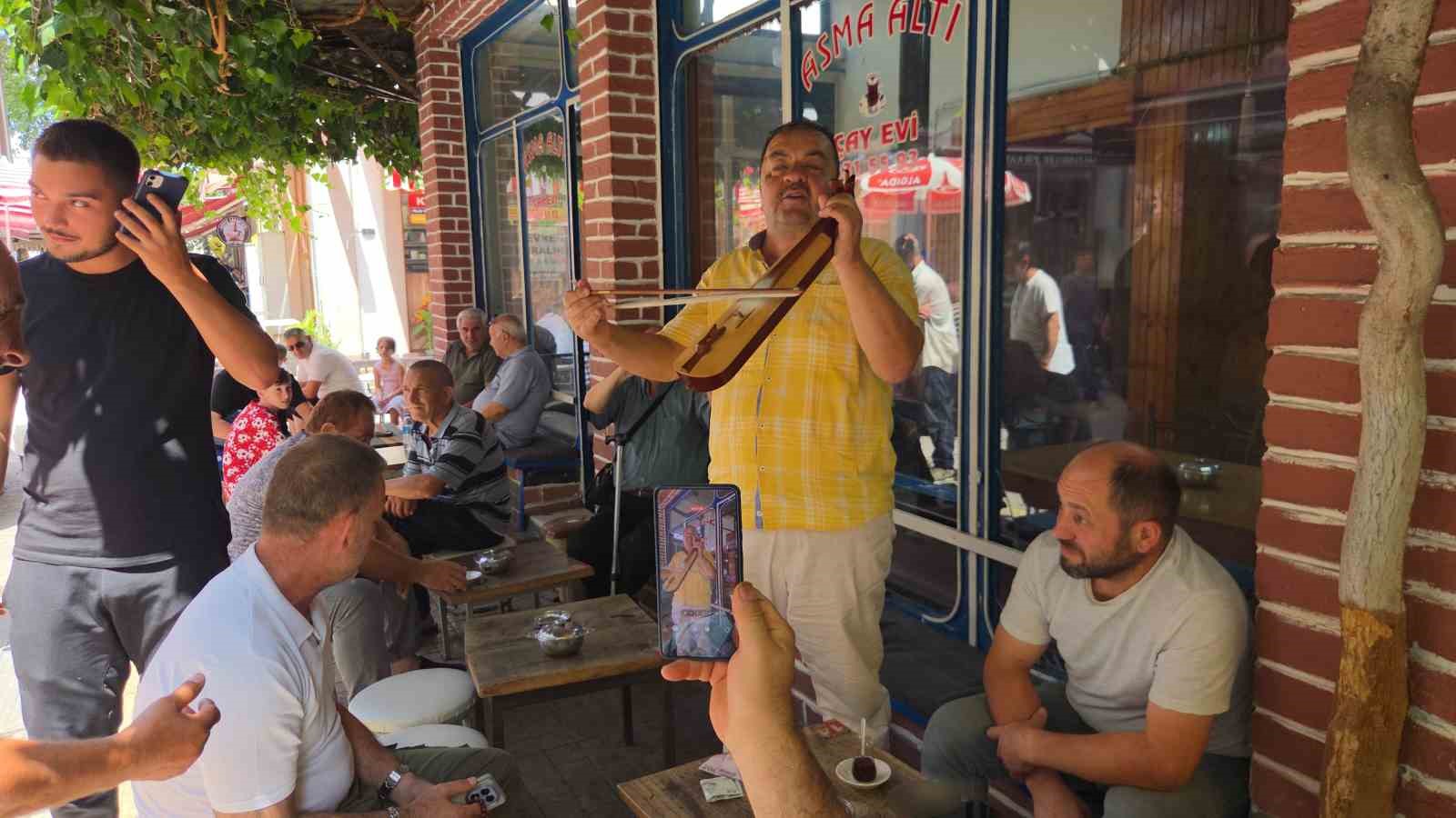 SAMSUN’DA ÇAY OCAĞINDA KEMENÇE ÇALAN ÇALGICI, MÜŞTERİLERİN VE ÇEVREDEN GEÇENLERİN İLGİ ODAĞI OLDU. AHALİ, NEŞELİ TÜRKÜLERE OYNAYARAK EŞLİK EDERKEN BİR YANDAN DA CEP TELEFONLARI İLE KAYIT YAPTI.