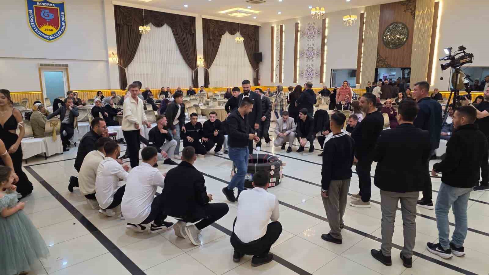 BALIKESİR'İN BANDIRMA İLÇESİNDE DÜZENLENEN DÜĞÜNDE, DAMADIN TIR ŞOFÖRÜ OLMASI NEDENİYLE ARKADAŞLARI TARAFINDAN TAKI OLARAK TIR LASTİĞİ HEDİYE EDİLDİ. ALIŞILMIŞIN DIŞINDAKİ TAKI MERASİMİ, DÜĞÜNE KATILANLARIN ŞAŞKINLIKLA İZLEDİĞİ ANLARA SAHNE OLDU.