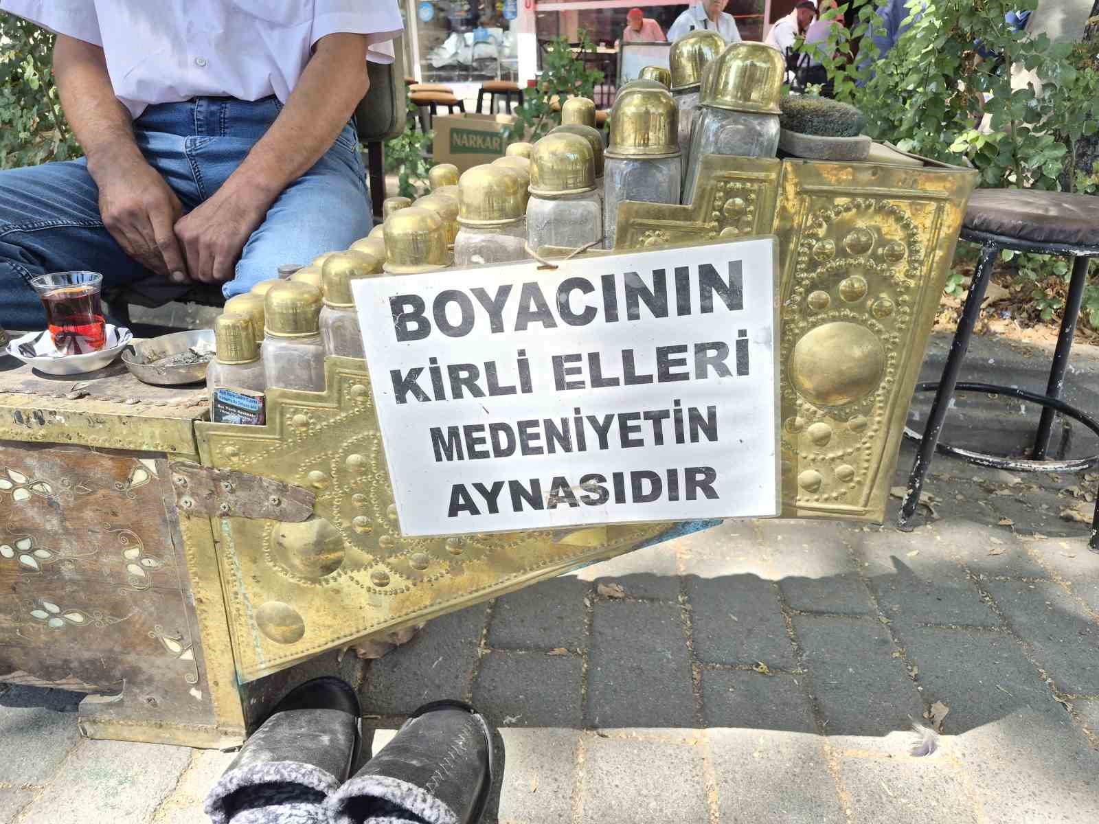 ESKİŞEHİR'DE SEYYAR ESNAFLIK YAPAN AYAKKABI BOYACISI ORHAN KURUÇ, TEZGAHINA ASTIĞI YAZI İLE VATANDAŞLARIN İLGİSİNİ ÇEKTİ.