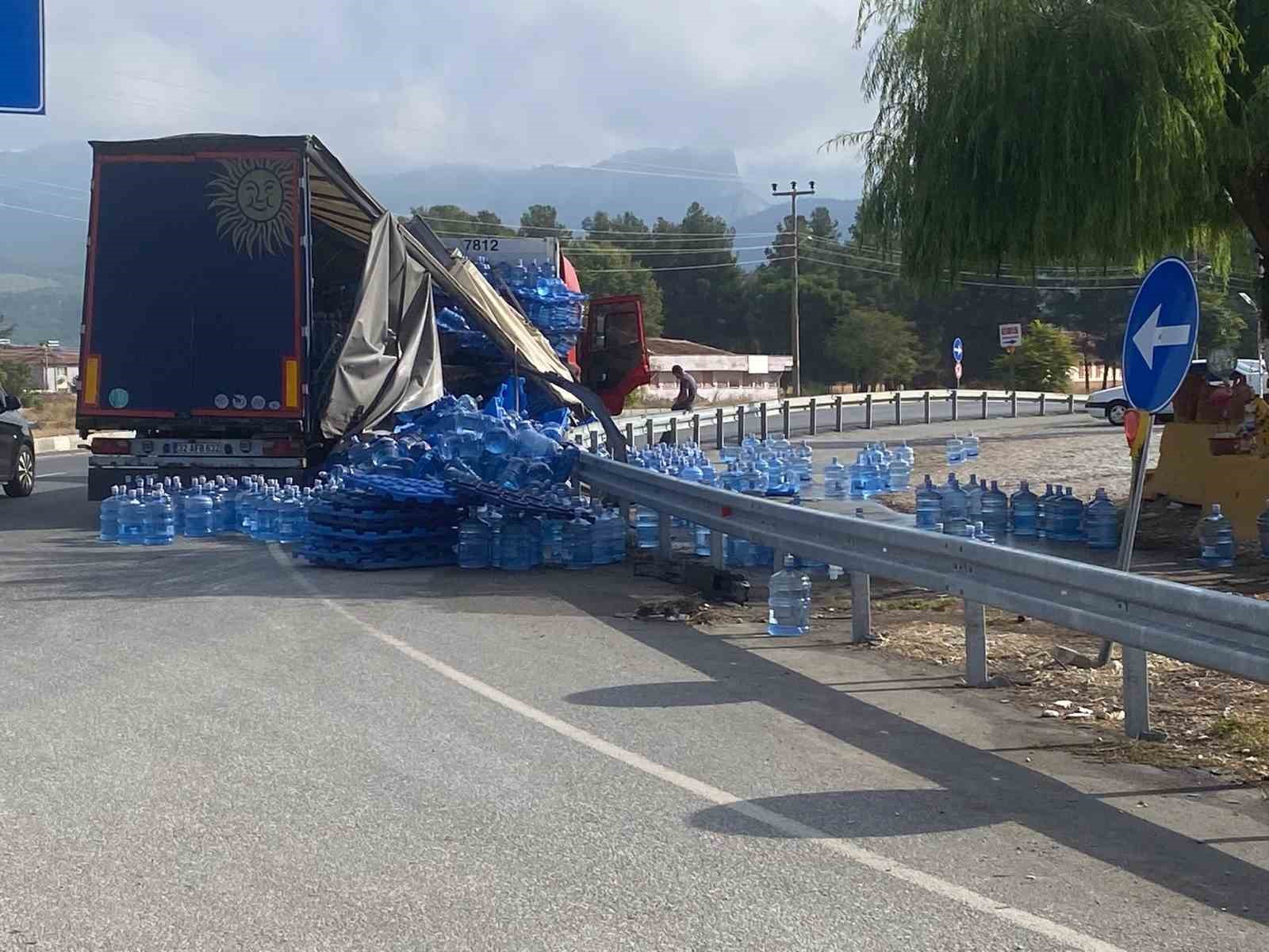 DENİZLİ’NİN BOZKURT İLÇESİ GİRİŞİNDEKİ KAVŞAKTA VİRAJI ALAMAYAN SU YÜKLÜ TIR YAN YATTI. DORSENİN ÖRTÜSÜNÜN KIRILMASI SONUCU SU ŞİŞELERİ VE DAMACANALAR YOLA SAVRULDU.
