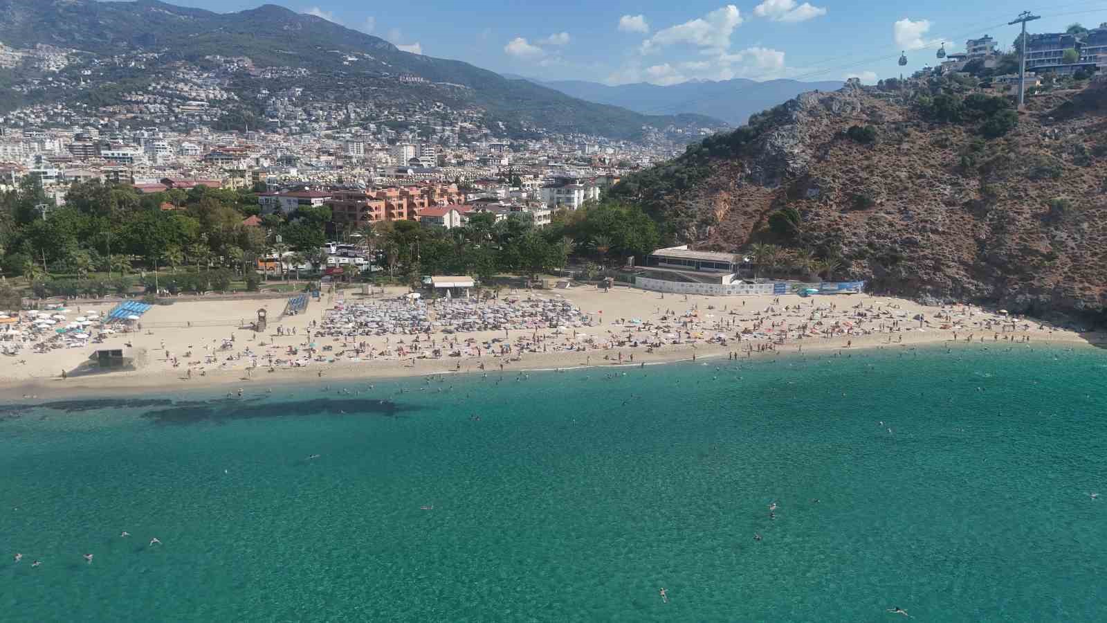 HAVA SICAKLIĞININ 26, DENİZ SUYU SICAKLIĞININ İSE 25 DERECE ÖLÇÜLDÜĞÜ KENTTE, YERLİ VE YABANCI TURİSTLER KLEOPATRA PLAJI'NI DOLDURDU.